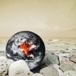 Earth surrounded by cracked and dry land representing environmental degradation.