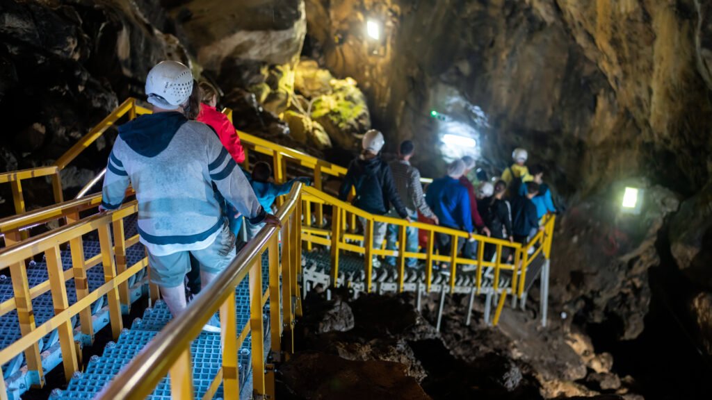 Underground mining site with miners and equipment extracting minerals.